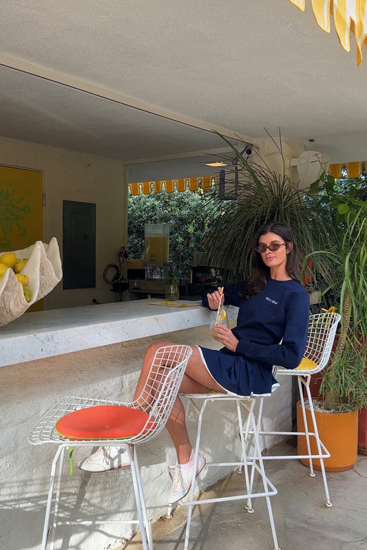 Woman sitting in a navy sweatshirt at a summer bar